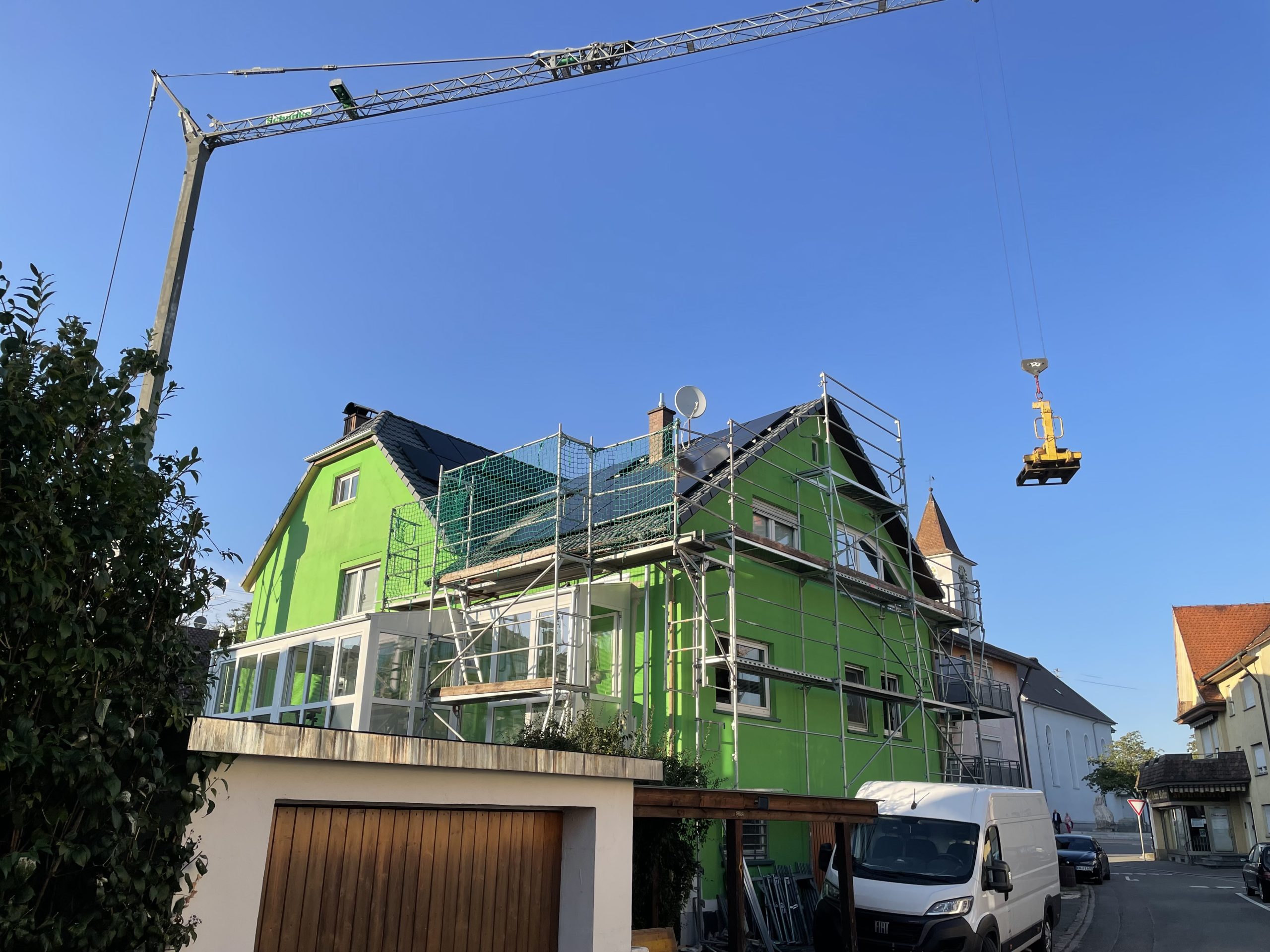 Baustelle mit Gerüst und Kran bei der Dachmontage